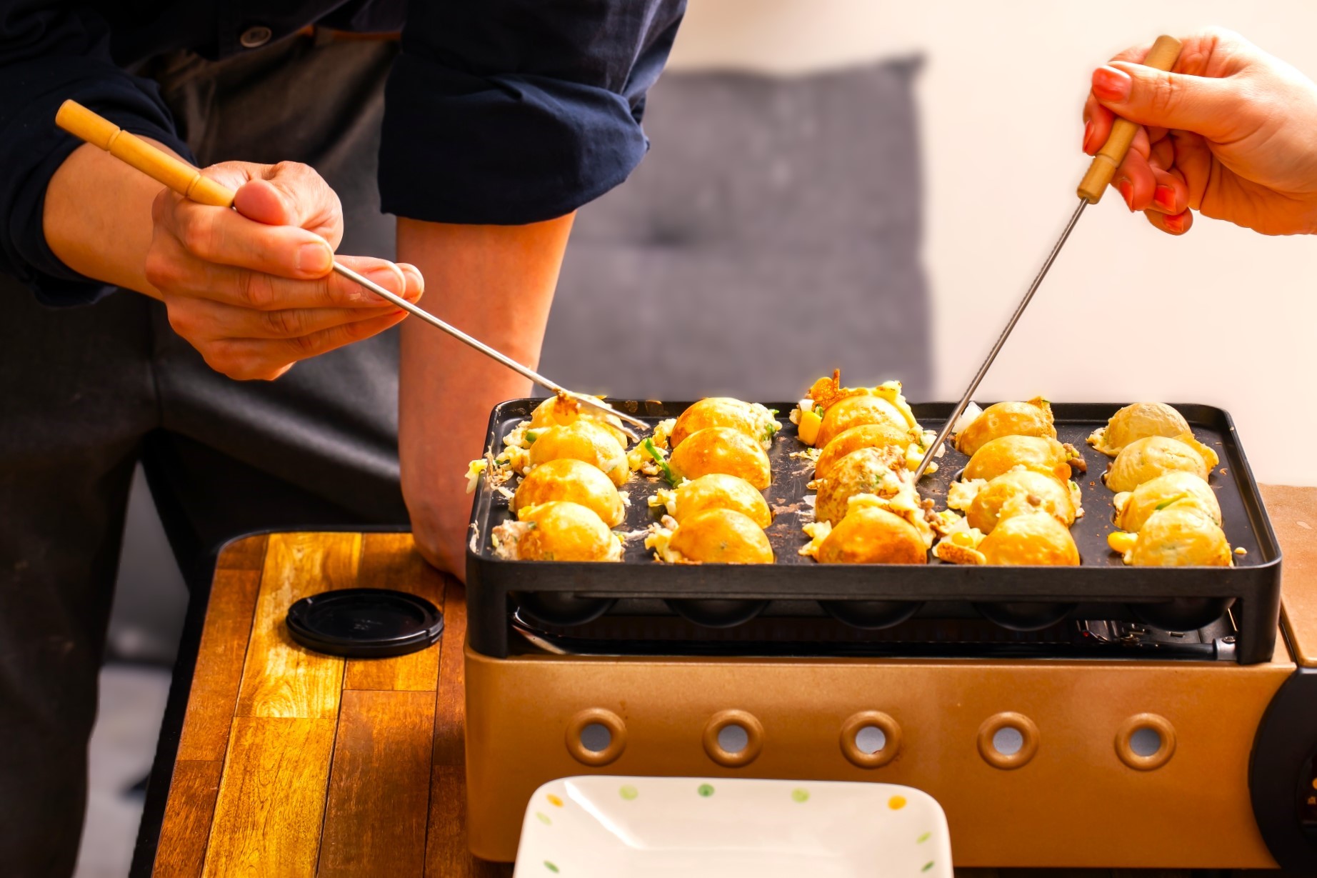 鉄板の丸い穴に水と卵で作った小麦粉の生地を流し込み、中にぶつ切りにしたタコを入れて丸く焼きます